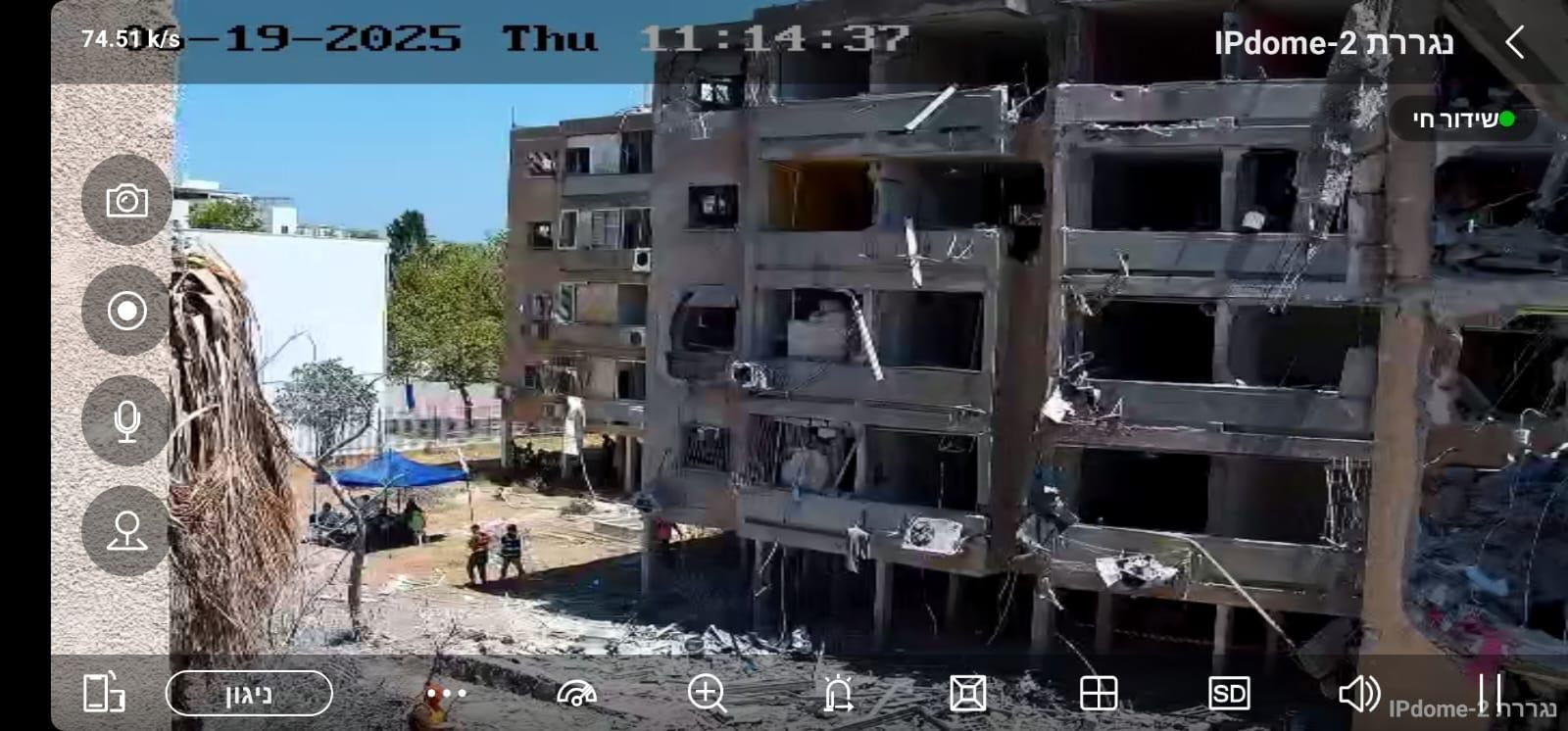 Live feed from an AI-EYE IN THE SKY trailer camera as seen in the military control room: a residential building hit by an Iranian missile on 19 June 2025, with rescue teams on the ground