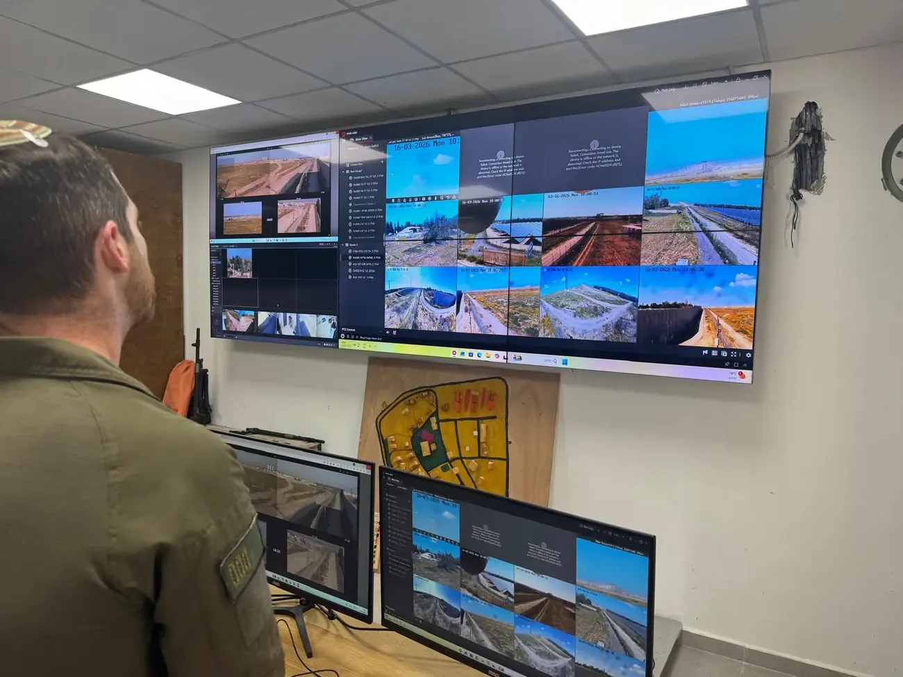 An operator in front of the D-Command Control video wall in a control room.