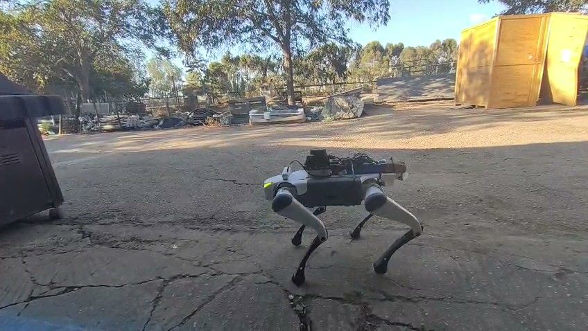 D-DOG walking across a cracked yard with its compute and communication payload