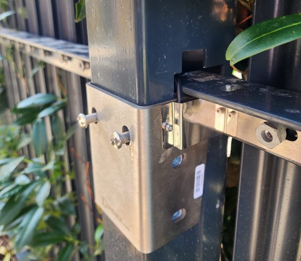 Close-up of the stainless-steel D-Palisade bracket clamping the post and the rail