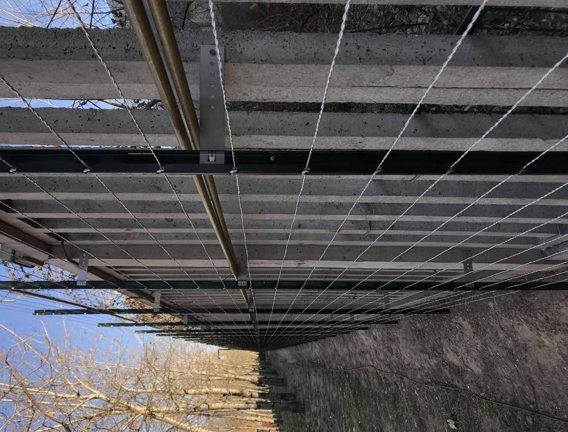 Horizontal taut wires and sensor posts added to an existing concrete-slat railway fence