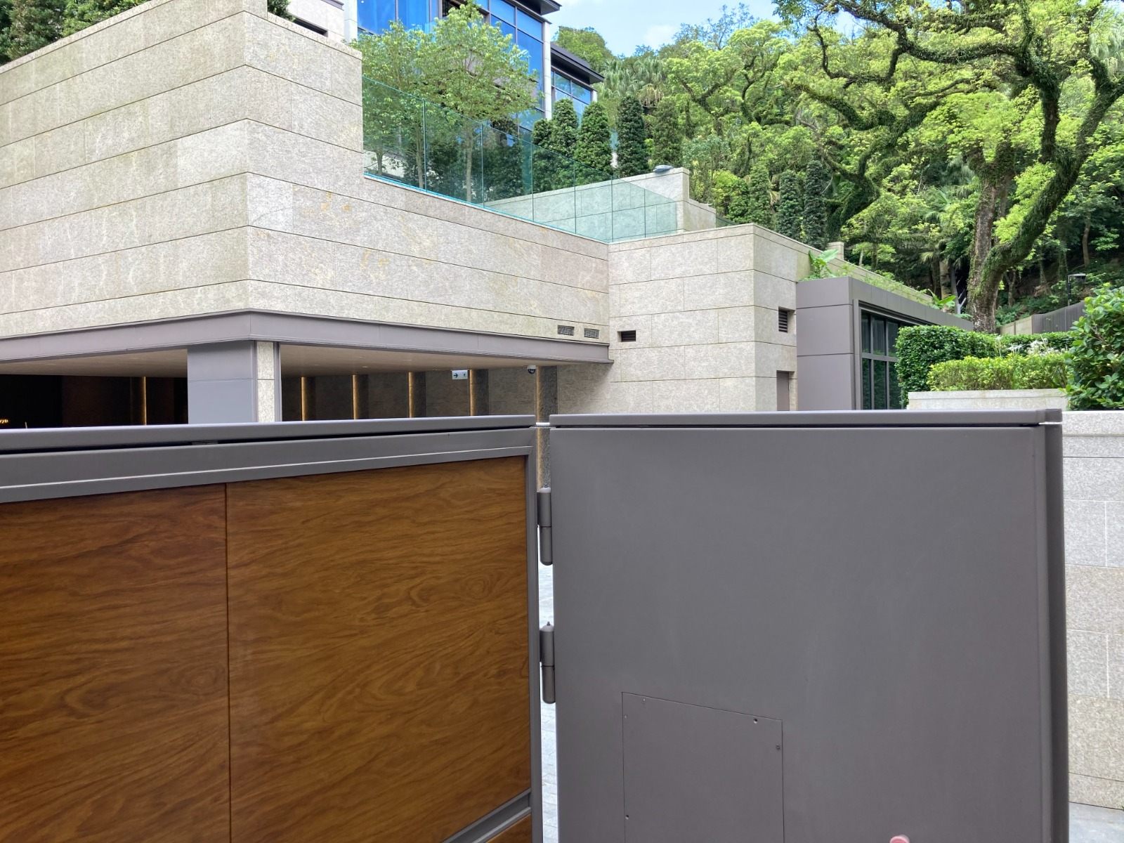 Driveway gate of a hillside residence with timber and metal panels, protected by D-Tech on the gate