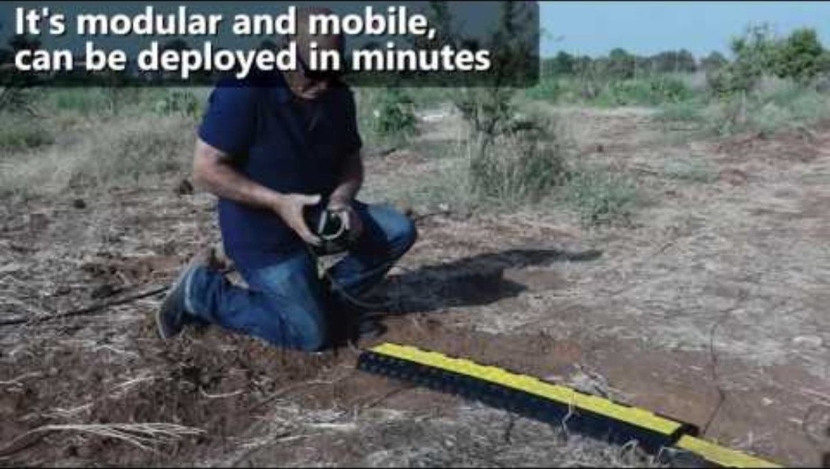 Field photo: a technician kneels on bare ground connecting a yellow mobile D-Truck Strip; caption 'It's modular and mobile, can be deployed in minutes'