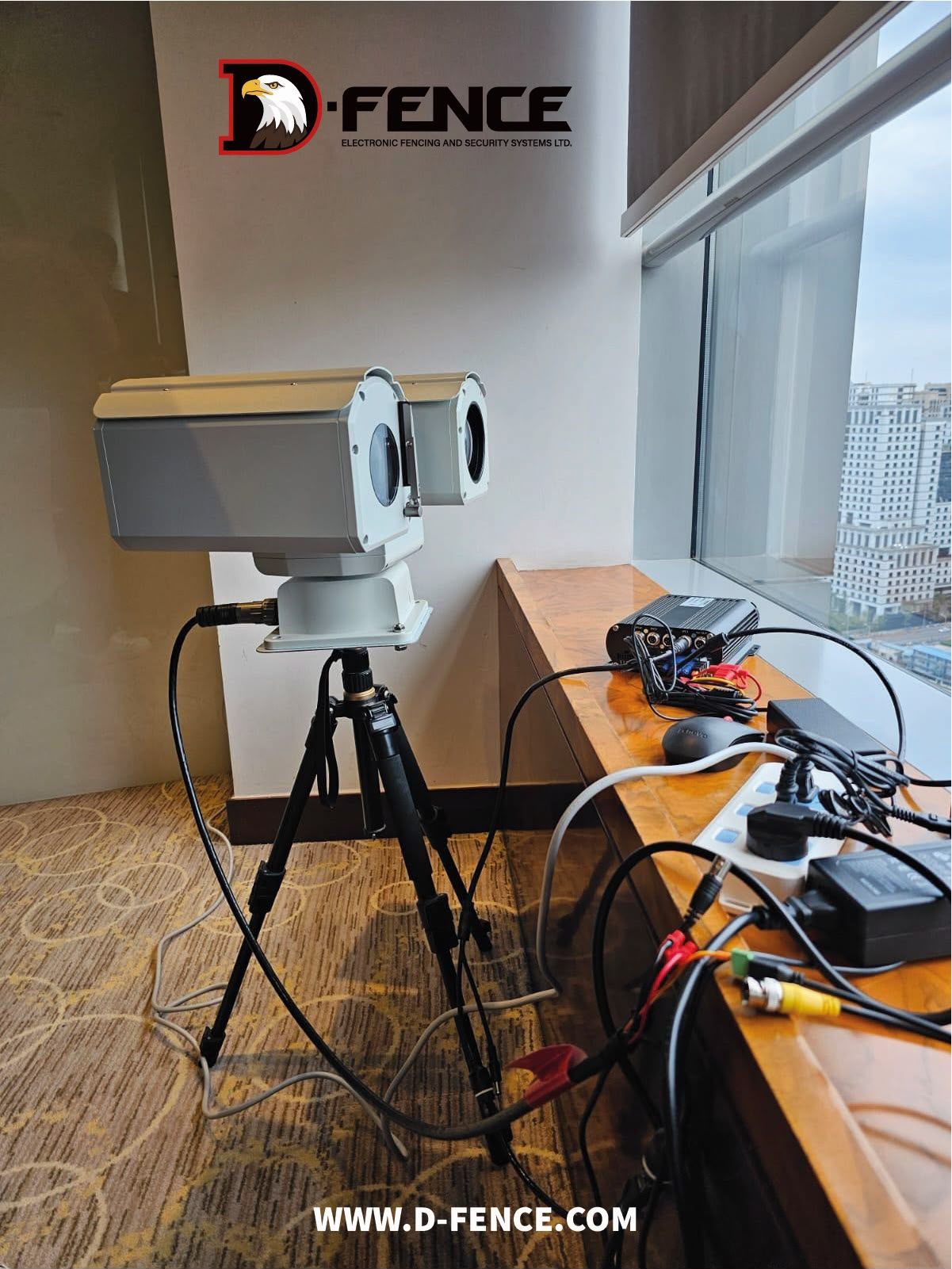 NOA bi-spectrum head on a tripod by a high-rise window, cabled to a recorder on the window sill